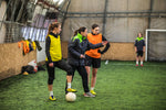 A football coach speaking to two players on the football field