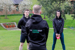 A The Fitness Group instructor guiding students in how to use kettlebells