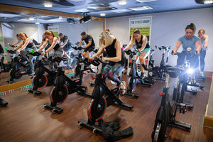 A group of people in a studio cycling session