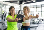 A gym instructor helping a gym goer with an exercise