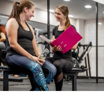 A gym instructor talking to a gym goer