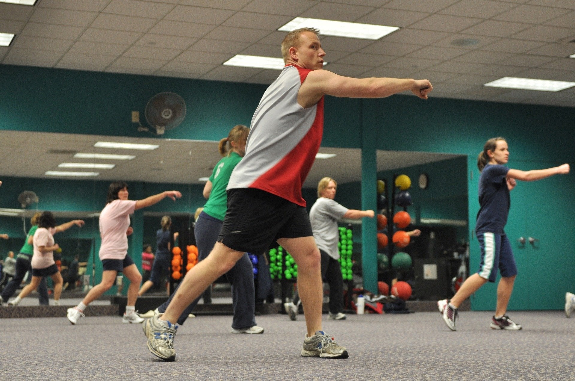 A group exercise instructor leading a class in a gym